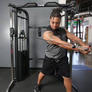 man using titan fitness functional trainer to do cross body exercise