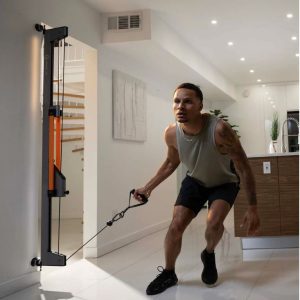 man next to kitchen using the tut trainer tower for workout