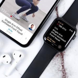 viewing the Future fitness app on a phone screen with a women performing a kettlebell squat, next to the companion workout screen on a fitness smartwatch