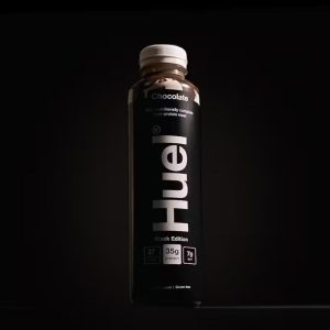 a bottle of the meal replacement shake huel black edition on a dark background
