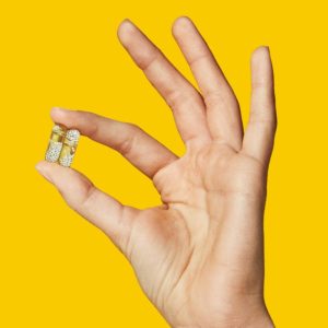 Hand holding capsule of vitamins