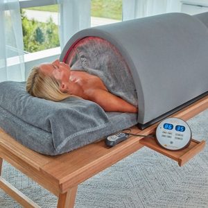 A woman is lying down in the Sunlighten Solo Portable Sauna