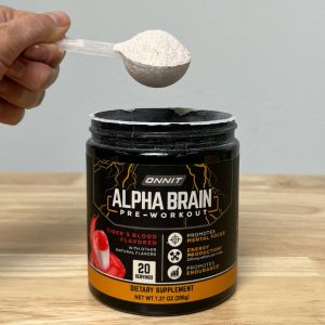a hand holding a scoop of onnit alpha brain pre workout