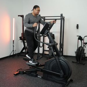 A man works out on a NordicTrack AirGlide 14i Elliptical.