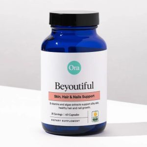 the ora organic beyoutiful skin, hair, and nails support supplement placed on a white table, with a gray background