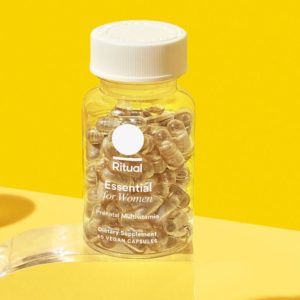 A bright yellow-themed bottle of Ritual Omega-3 dietary supplement, containing DHA and EPA derived from microalgae, presented with 30 vegan capsules inside.